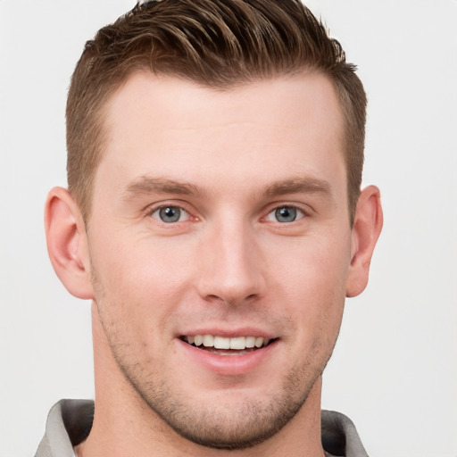 Joyful white young-adult male with short  brown hair and grey eyes