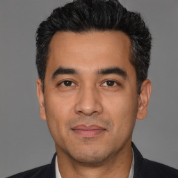 Joyful white adult male with short  black hair and brown eyes