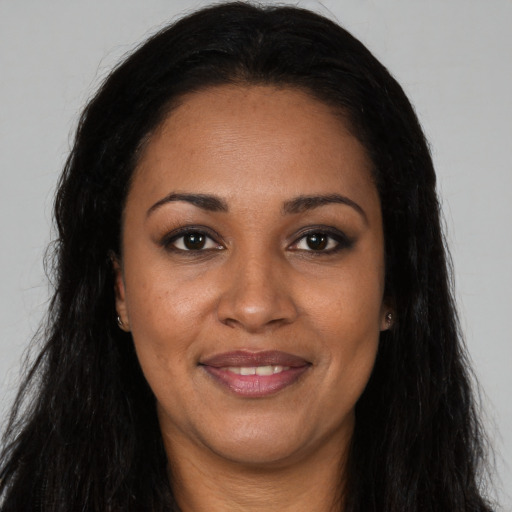 Joyful black young-adult female with long  brown hair and brown eyes