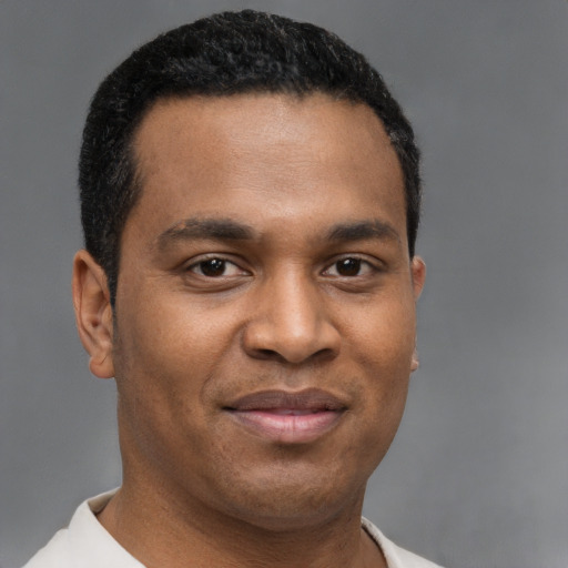 Joyful latino young-adult male with short  brown hair and brown eyes