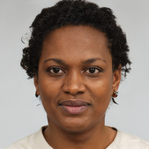 Joyful black adult female with short  black hair and brown eyes