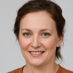 Joyful white adult female with medium  brown hair and brown eyes