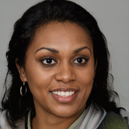 Joyful black young-adult female with long  brown hair and brown eyes