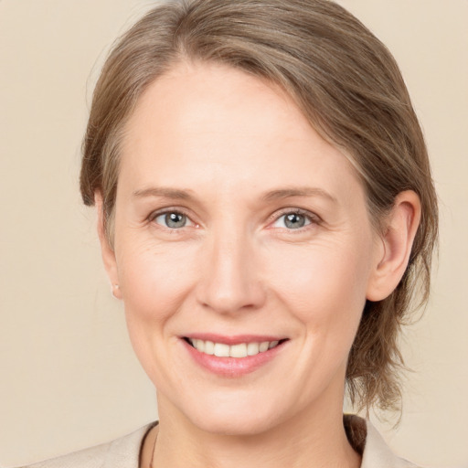 Joyful white adult female with medium  brown hair and grey eyes