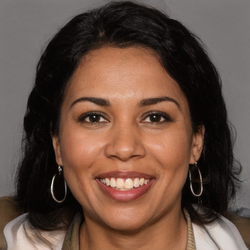 Joyful latino young-adult female with medium  brown hair and brown eyes