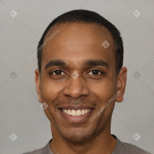 Joyful black adult male with short  black hair and brown eyes