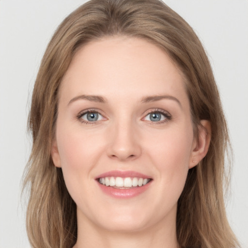 Joyful white young-adult female with long  brown hair and grey eyes