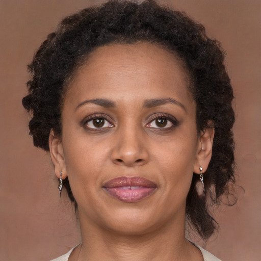 Joyful black adult female with medium  brown hair and brown eyes