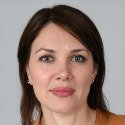 Joyful white adult female with medium  brown hair and brown eyes