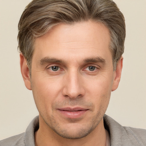 Joyful white adult male with short  brown hair and grey eyes