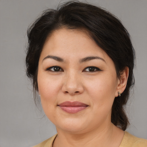 Joyful asian adult female with medium  brown hair and brown eyes