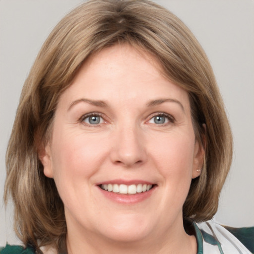 Joyful white adult female with medium  brown hair and grey eyes