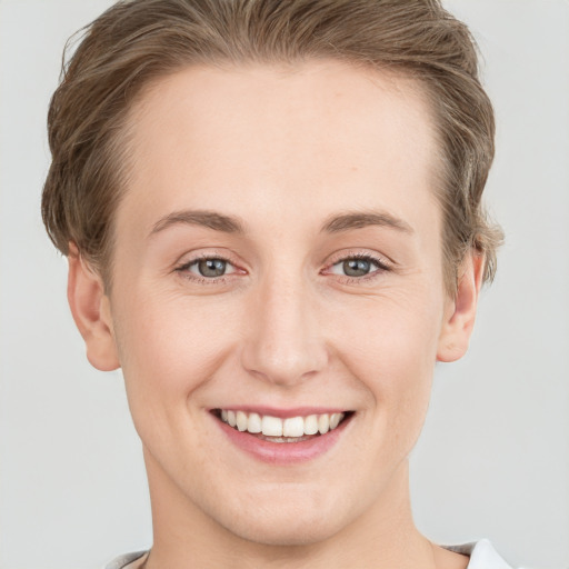 Joyful white young-adult female with short  brown hair and grey eyes