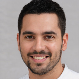 Joyful white young-adult male with short  black hair and brown eyes