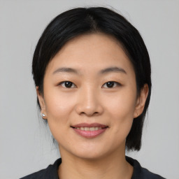 Joyful asian young-adult female with medium  black hair and brown eyes