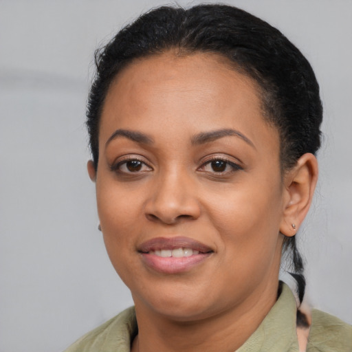 Joyful black young-adult female with short  black hair and brown eyes