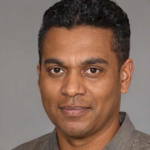 Joyful black adult male with short  black hair and brown eyes