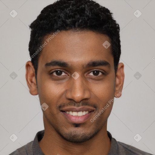 Joyful black young-adult male with short  black hair and brown eyes