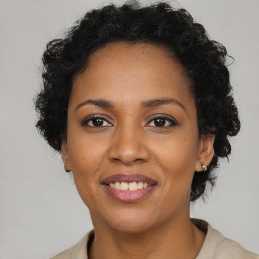 Joyful black young-adult female with short  brown hair and brown eyes
