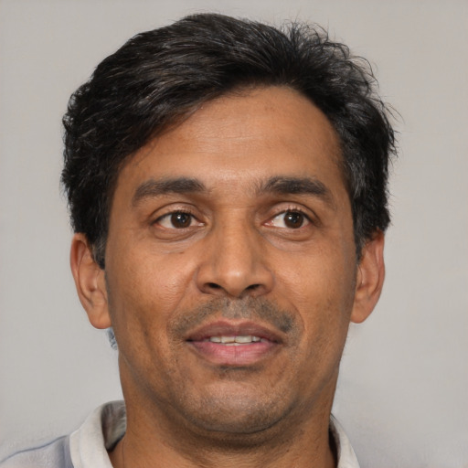 Joyful latino adult male with short  black hair and brown eyes