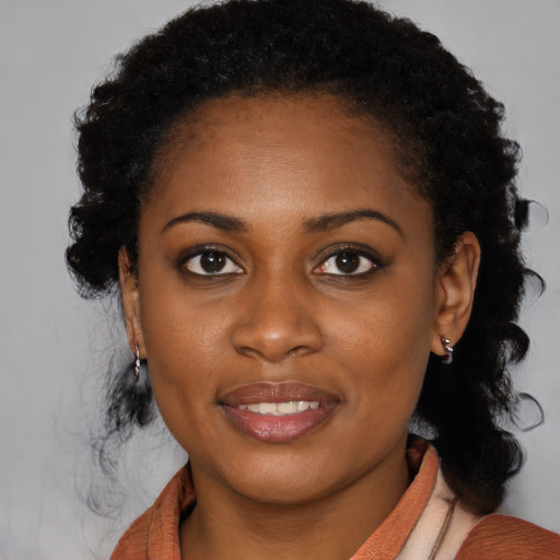 Joyful black young-adult female with long  black hair and brown eyes