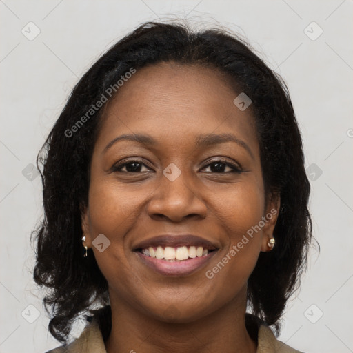 Joyful black young-adult female with long  brown hair and brown eyes