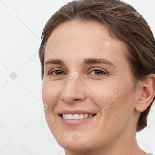 Joyful white young-adult female with medium  brown hair and grey eyes