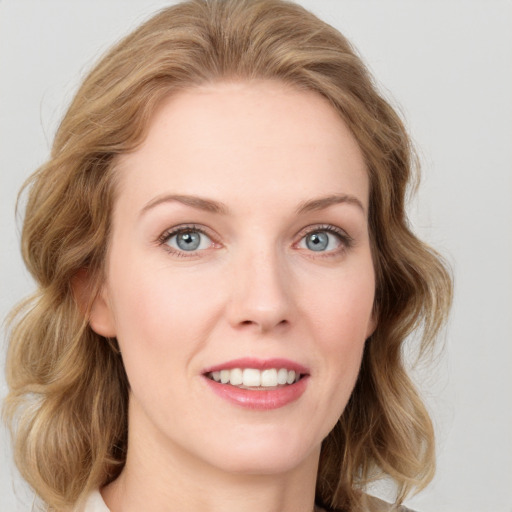 Joyful white young-adult female with medium  brown hair and blue eyes