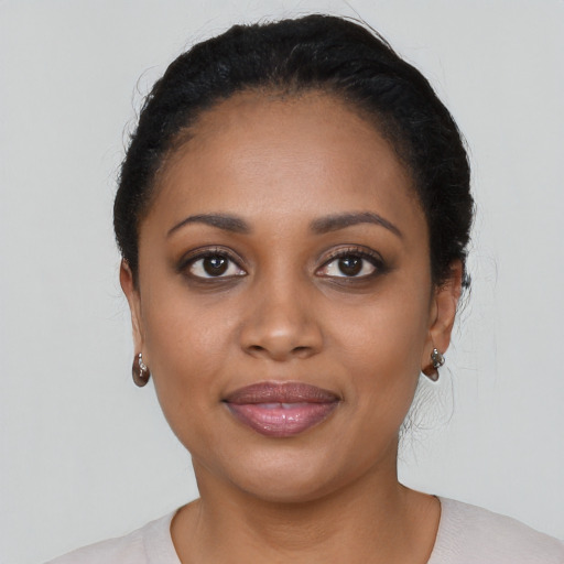 Joyful black young-adult female with long  black hair and brown eyes