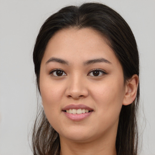 Joyful white young-adult female with long  brown hair and brown eyes
