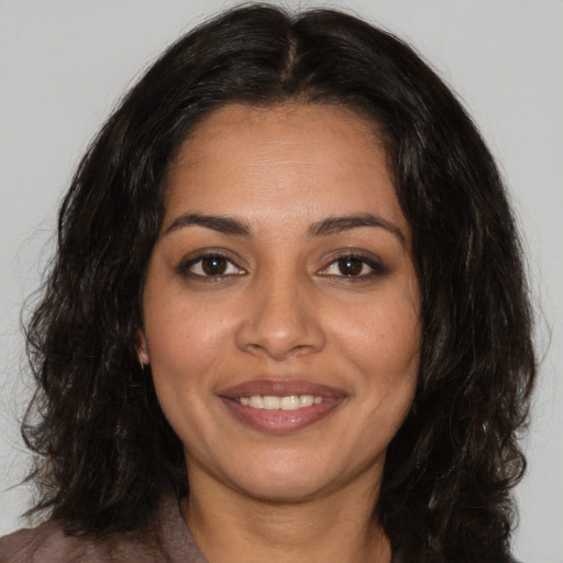 Joyful latino young-adult female with medium  brown hair and brown eyes