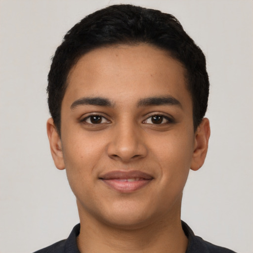 Joyful latino young-adult male with short  black hair and brown eyes