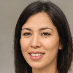 Joyful asian young-adult female with long  brown hair and brown eyes