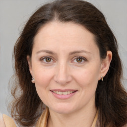 Joyful white adult female with long  brown hair and brown eyes