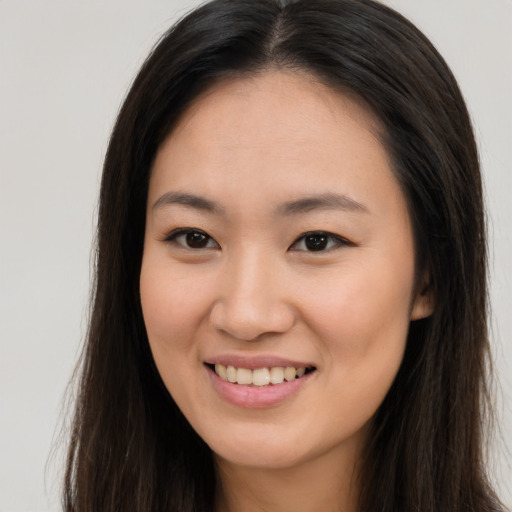 Joyful asian young-adult female with long  brown hair and brown eyes