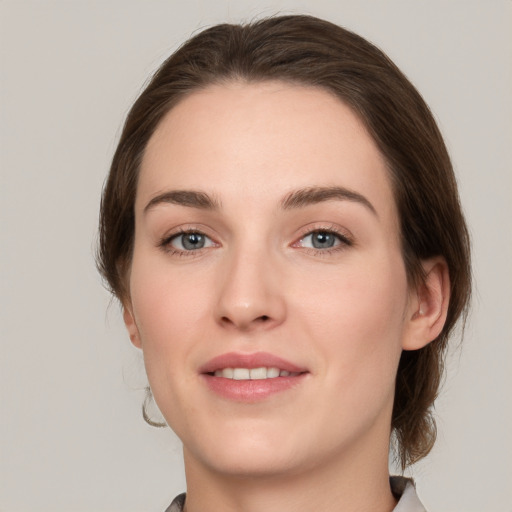 Joyful white young-adult female with medium  brown hair and grey eyes