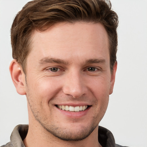 Joyful white young-adult male with short  brown hair and grey eyes