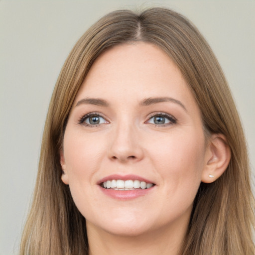 Joyful white young-adult female with long  brown hair and grey eyes