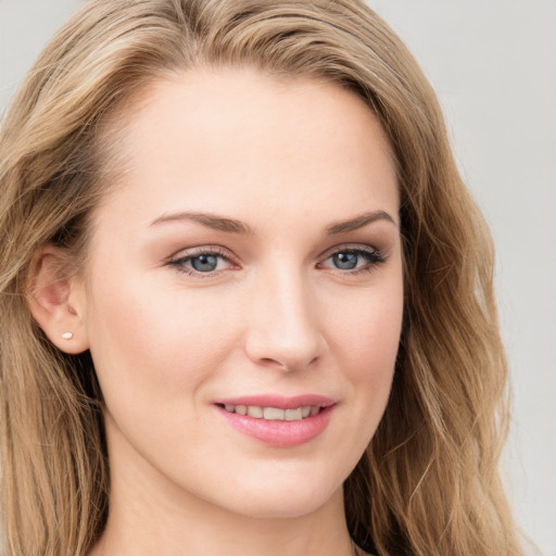 Joyful white young-adult female with long  brown hair and blue eyes