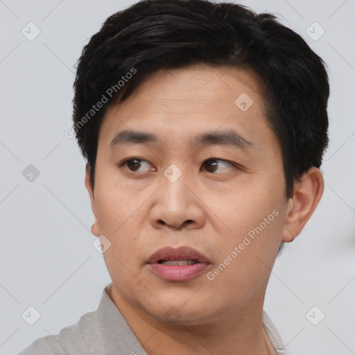 Joyful asian young-adult male with short  black hair and brown eyes