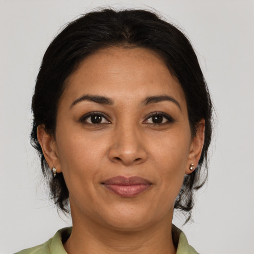 Joyful latino adult female with medium  brown hair and brown eyes