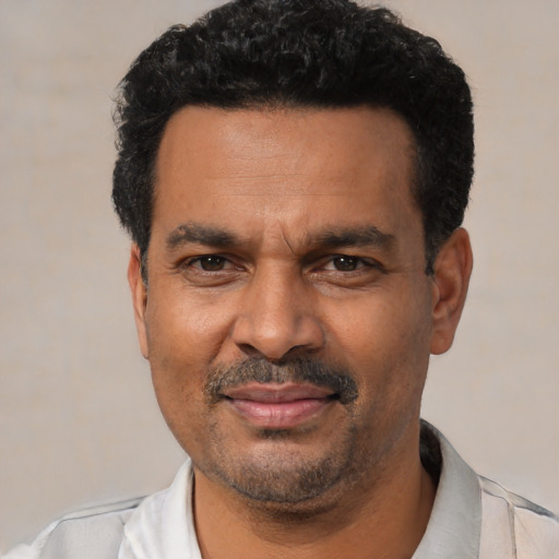 Joyful latino adult male with short  black hair and brown eyes