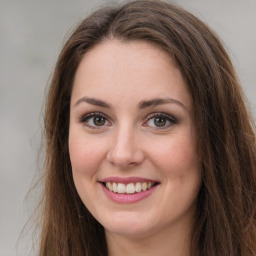 Joyful white young-adult female with long  brown hair and green eyes