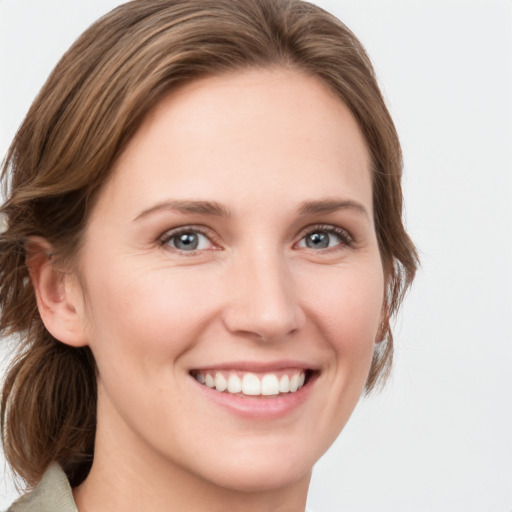 Joyful white young-adult female with medium  brown hair and grey eyes