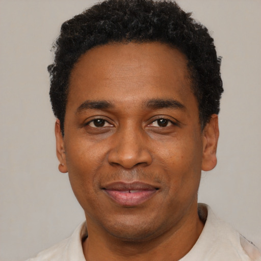 Joyful black adult male with short  black hair and brown eyes