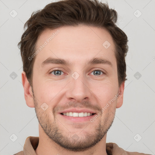 Joyful white young-adult male with short  brown hair and grey eyes