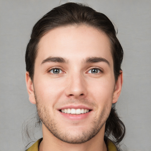 Joyful white young-adult male with short  brown hair and brown eyes