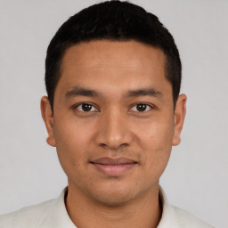 Joyful latino young-adult male with short  black hair and brown eyes