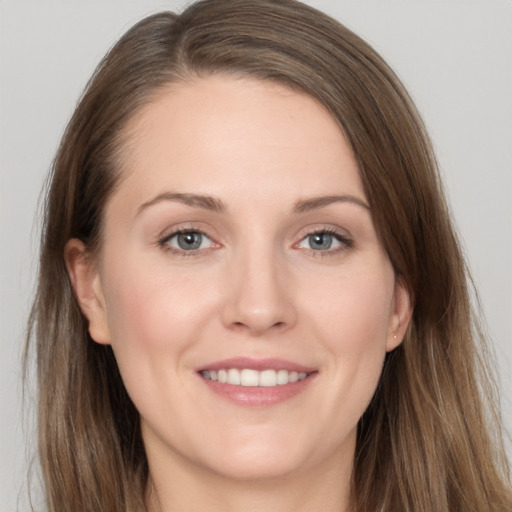 Joyful white young-adult female with long  brown hair and grey eyes