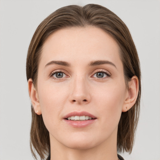 Joyful white young-adult female with medium  brown hair and grey eyes